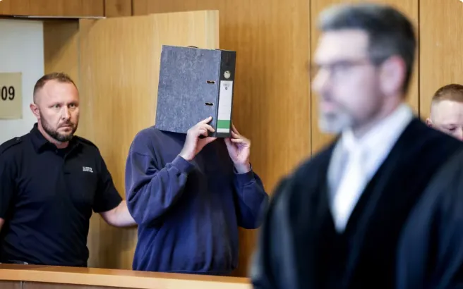 Y tá che mặt khi bước vào phòng xử án hôm 5/11 (Ảnh: DPA/AP)