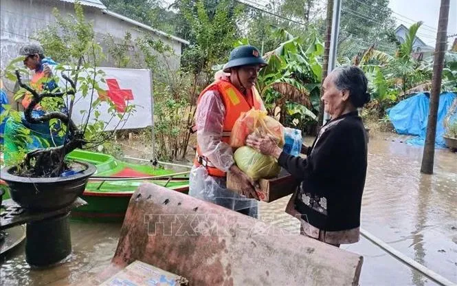 Cán bộ, tình nguyện viên Chữ thập đỏ cứu trợ người dân bị ảnh hưởng bởi mưa lũ tại thành phố Huế. Ảnh: TTXVN phát