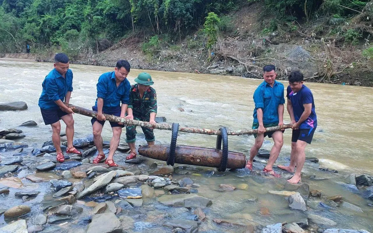 Lực lượng chức năng di chuyển quả bom khỏi lòng sông sau khi đã vô hiệu hóa kíp nổ (Ảnh: Trọng Kiên).