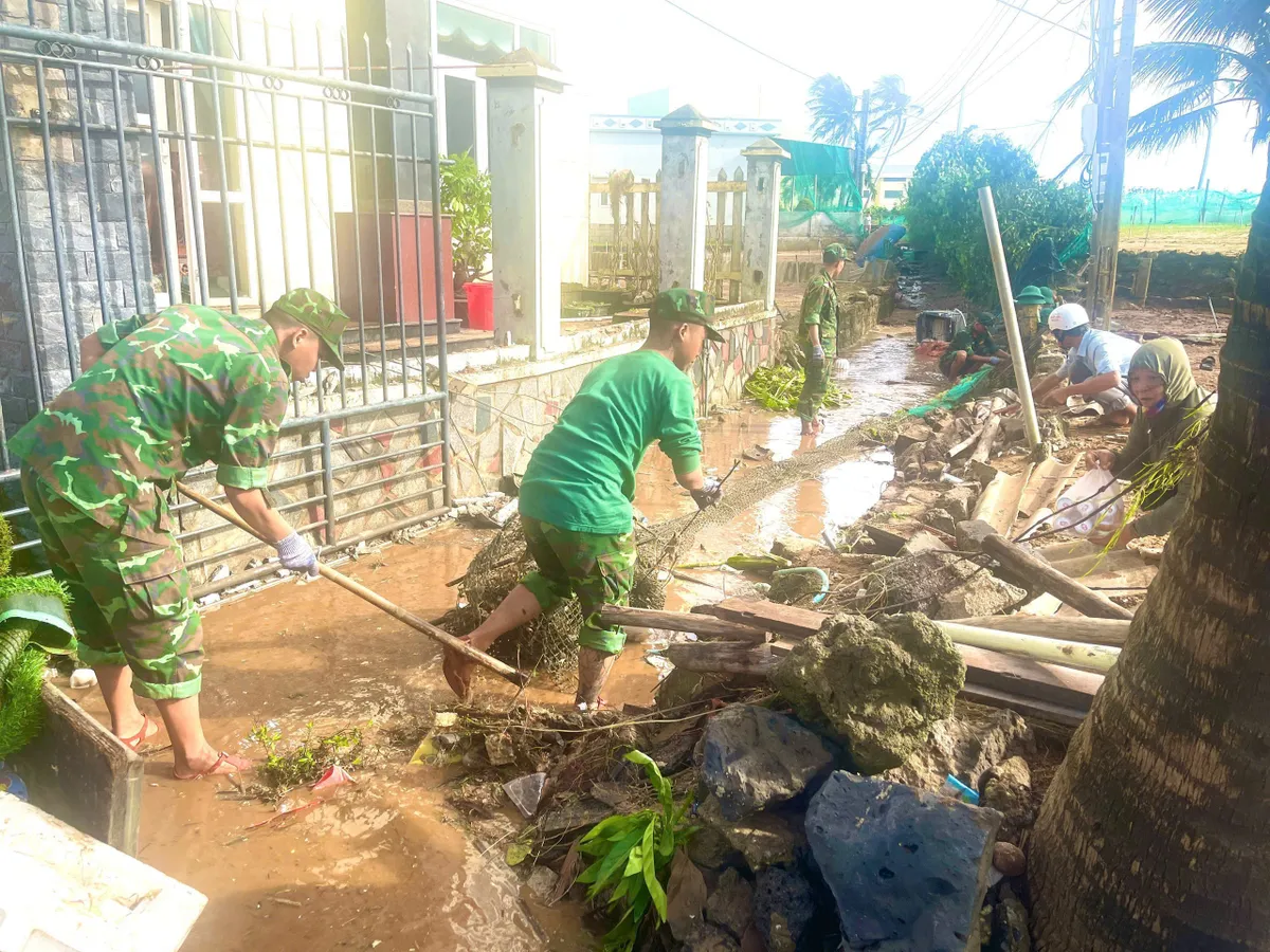 Quảng Ngãi: Cán bộ, chiến sĩ hỗ trợ người dân khắc phục hậu quả cơn bão số 13 - Ảnh 1.