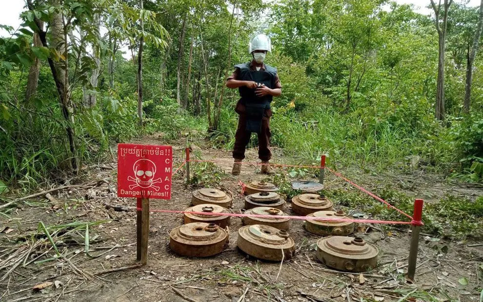 Nhân sự của Trung tâm Hành động bom mìn Campuchia (CMAC) bên số bom mìn chưa phát nổ (Ảnh minh họa: CMAC)