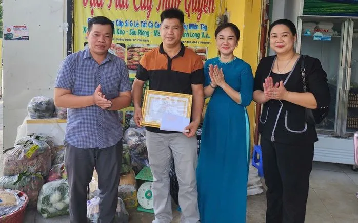 Bà Nguyễn Thị Kim Loan (áo xanh) cùng đại diện lãnh đạo Đảng ủy, HĐND đặc khu Phú Quốc trao tặng giấy khen cho anh Trần Hoàng Phương. Ảnh: NLĐ