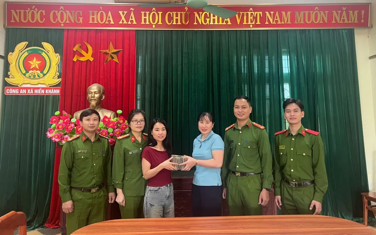 Chị Đỗ Thị Ngà (áo đỏ) trả lại số tiền 400 triệu đồng cho chị Nguyễn Thị Hà (áo xanh). Ảnh Công an xã Hiển Khánh