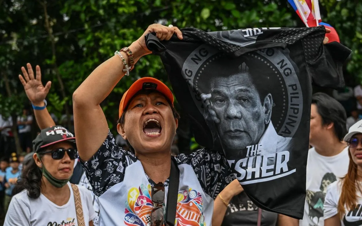 Một phụ nữ cầm chiếc áo có hình cựu Tổng thống Rodrigo Duterte trong cuộc biểu tình chống tham nhũng ở Philippines, ngày 16/11/2025 (Ảnh: AFP)