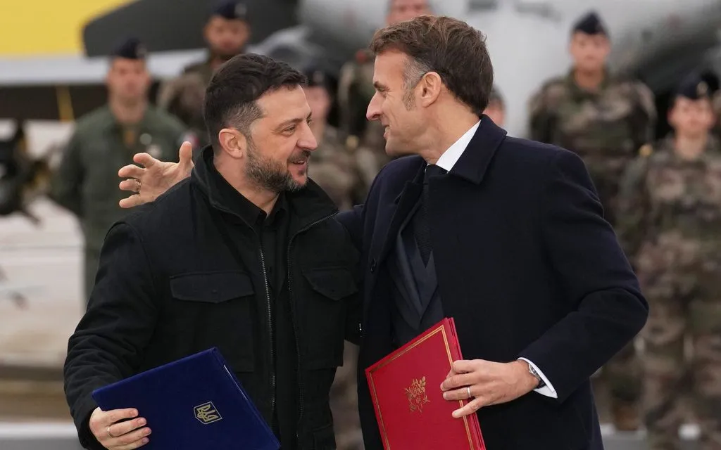 Tổng thống Pháp Emmanuel Macron và Tổng thống Ukraine Volodymyr Zelensky ôm nhau sau lễ ký kết tại căn cứ Villacoublay, gần Paris, ngày 17/11/2025. (Ảnh: AP)