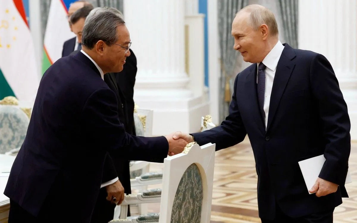 Tổng thống Nga Putin (phải) bắt tay Thủ tướng Trung Quốc Lý Cường trong cuộc gặp tại Moscow, ngày 18/11/2025 (Ảnh: AFP)