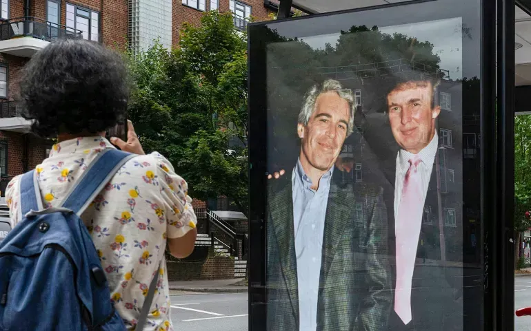 Các nhà hoạt động dán tấm áp phích có hình Tổng thống Donald Trump và Jeffrey Epstein gần đại sứ quán Hoa Kỳ tại London, Anh, ngày 17/7/2025 (Ảnh: AP)