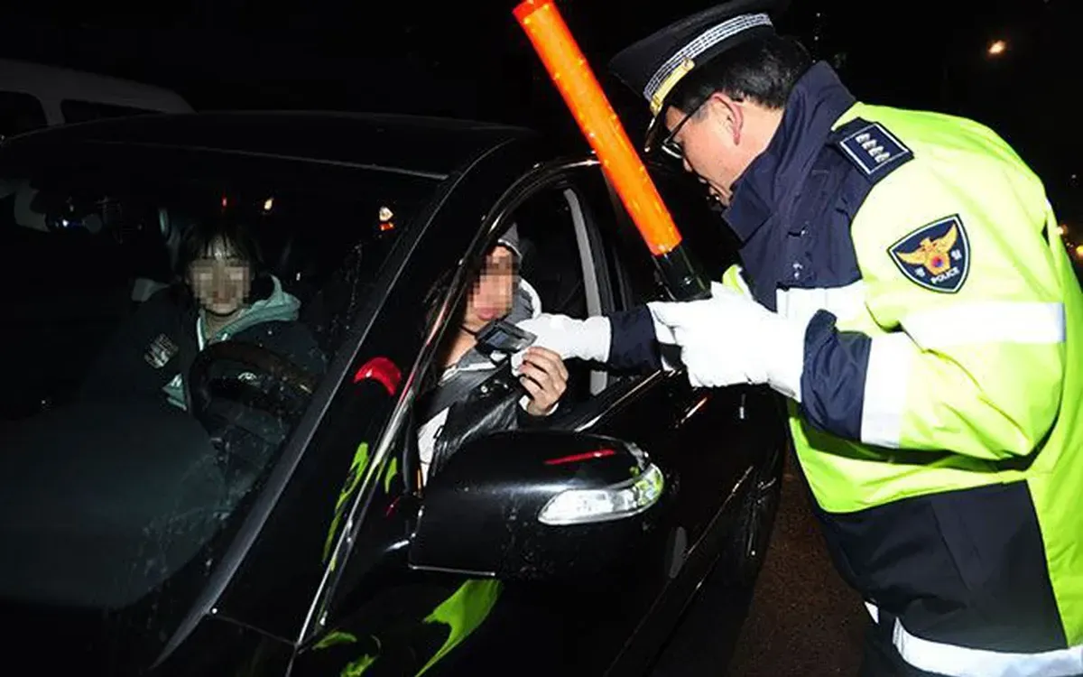 Cảnh sát Hàn Quốc kiểm tra nồng độ cồn của một tài xế trẻ. (Ảnh: AFP)