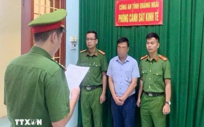 Lực lượng chức năng đọc quyết định khởi tố bị can đối với ông T.Đ.H. (Ảnh: TTXVN)