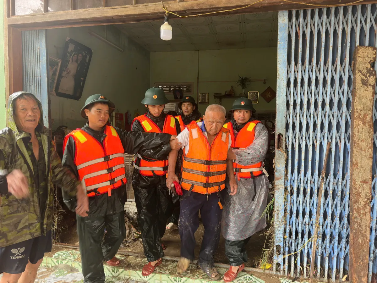 Những vòng tay bộ đội nâng đỡ người già trong biển nước lũ - Ảnh 2.