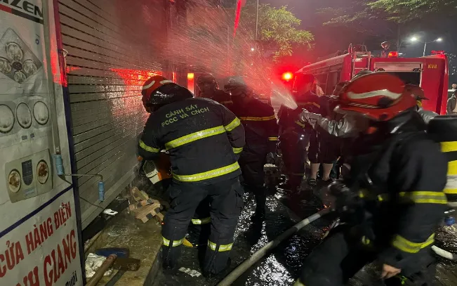 Lực lượng Cảnh sát PCCC&CNCH phá cửa cuốn tại tầng 1 để chữa cháy và cứu nạn cứu hộ. Ảnh: Cổng TTĐT Công an Hà Nội