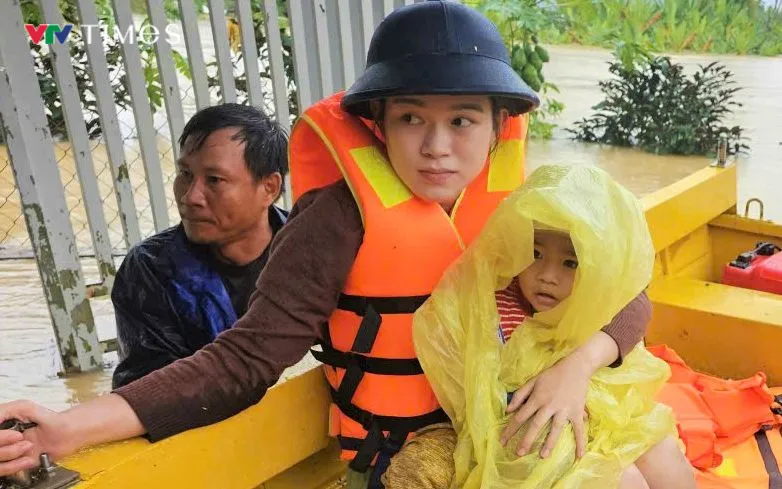 2 mẹ con được đưa lên xuồng ra khỏi khu vực mất an toàn.