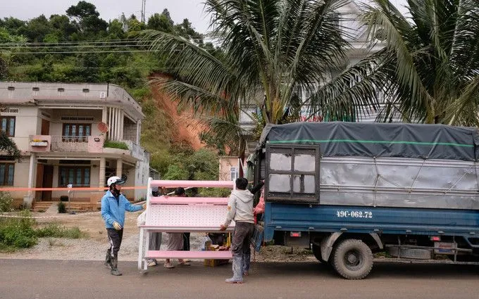 Lực lượng chức năng và chính quyền địa phương xã D’ran hỗ trợ 20 hộ dân di dời tài sản, đồ đạc đến nơi an toàn. Ảnh: TTXVN