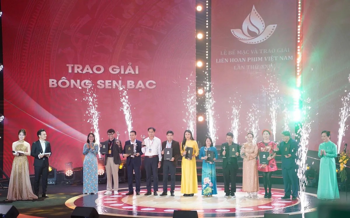 Đạo diễn, biên kịch Phạm Thùy Linh (áo vàng) thay mặt ê-kíp phim tài liệu "Tiếng nói của lương tri" đón nhận Giải thưởng Bông Sen Bạc tại LHP Việt Nam lần thứ XXIV 