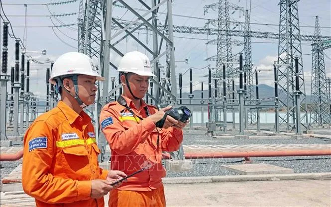 Cán bộ ngành điện giám sát trạm biến áp. Ảnh: Trần Việt/TTXVN