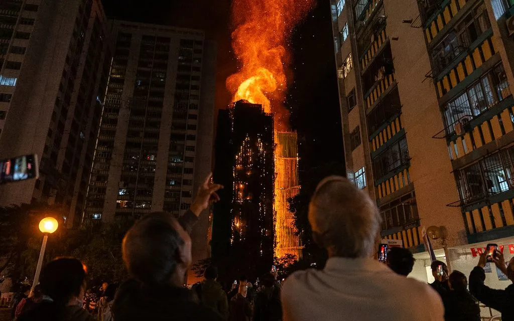 Người dân nhìn ngọn lửa bao trùm một tòa nhà tại khu chung cư Wang Fuk Court ở quận Tai Po, Hong Kong (Trung Quốc), ngày 26/11/2025. (Ảnh: AP)