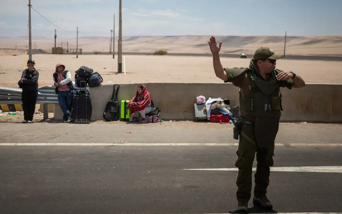 Một cảnh sát điều tiết giao thông tại cửa khẩu biên giới Chacalluta ở Arica, Chile, ngày 28/11/2025, khi những người di cư chờ nhập cảnh Peru (Ảnh: AP)