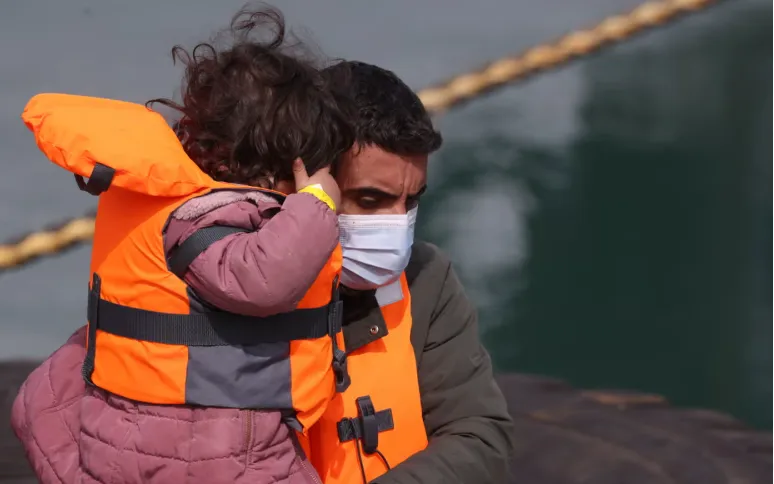 Trẻ em di cư được một sĩ quan Lực lượng Biên phòng Anh giúp đưa lên bờ tại Dover (Ảnh: Getty Images)