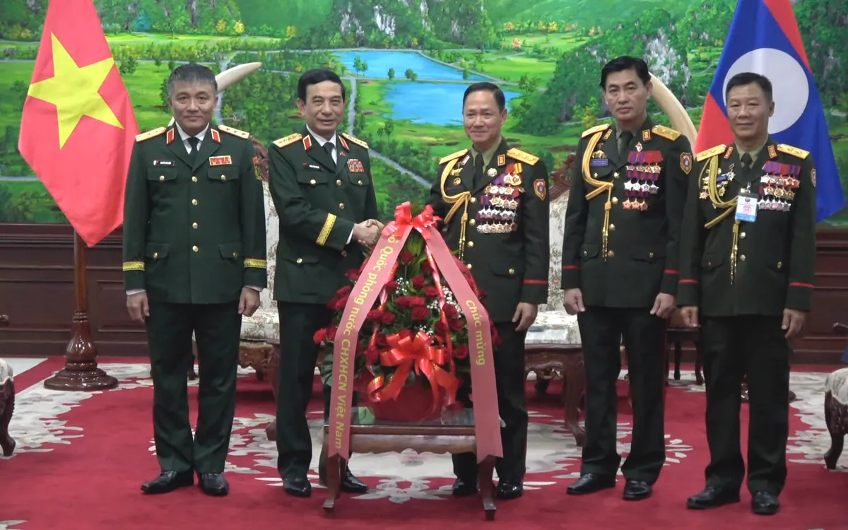Đại tướng Phan Văn Giang, Bộ trưởng Bộ Quốc phòng trao lẵng hoa chúc mừng 50 năm Quốc khánh Lào.