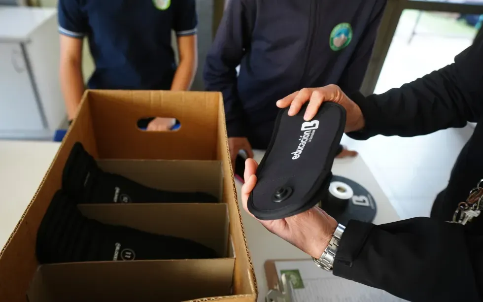 Một giáo viên phát thiết bị chặn tín hiệu để học sinh đặt điện thoại vào trong chương trình thí điểm hạn chế dùng điện thoại tại trường Bicentenario ở Santiago, Chile, ngày 8/9/2025 (Ảnh: AP)