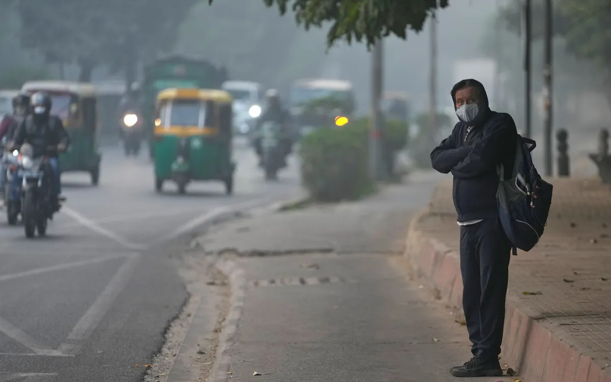 Người dân đeo khẩu trang chờ xe bus vào buổi sáng đầy sương mù ở New Delhi, Ấn Độ, ngày 18/11/2025 (Ảnh: AP)