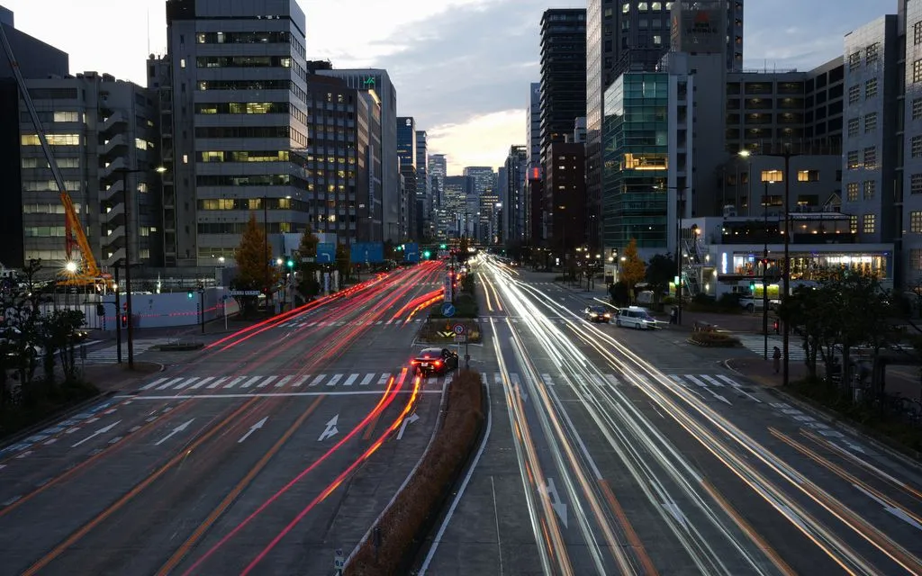 Phương tiện lưu thông qua đèn tín hiệu gần Công viên Central Park ở Nagoya, Nhật Bản, ngày 2/12/2025. (Ảnh: AP)