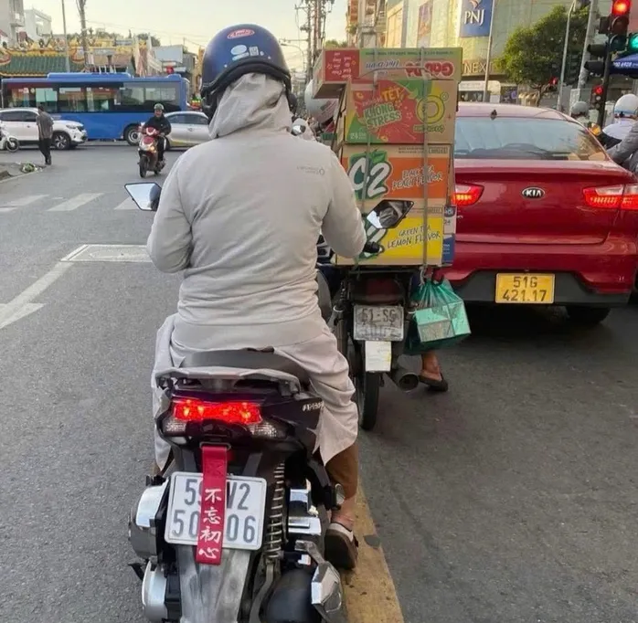 Xử phạt 2 phụ nữ ở TP Hồ Chí Minh dùng “bùa” che biển số xe máy - Ảnh 1.