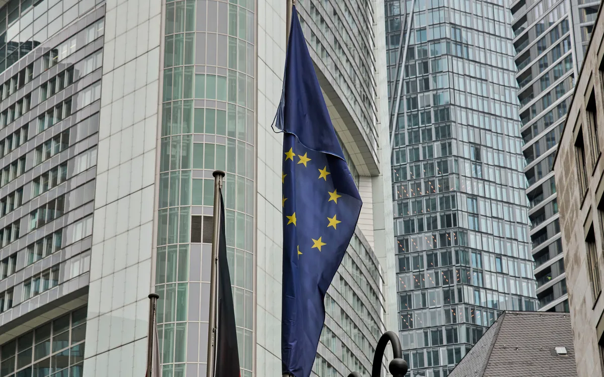 Một lá cờ châu Âu tung bay trước các tòa nhà ngân hàng ở Frankfurt, Đức, thứ sáu, ngày 25 tháng 4 năm 2025. (Ảnh: AP)