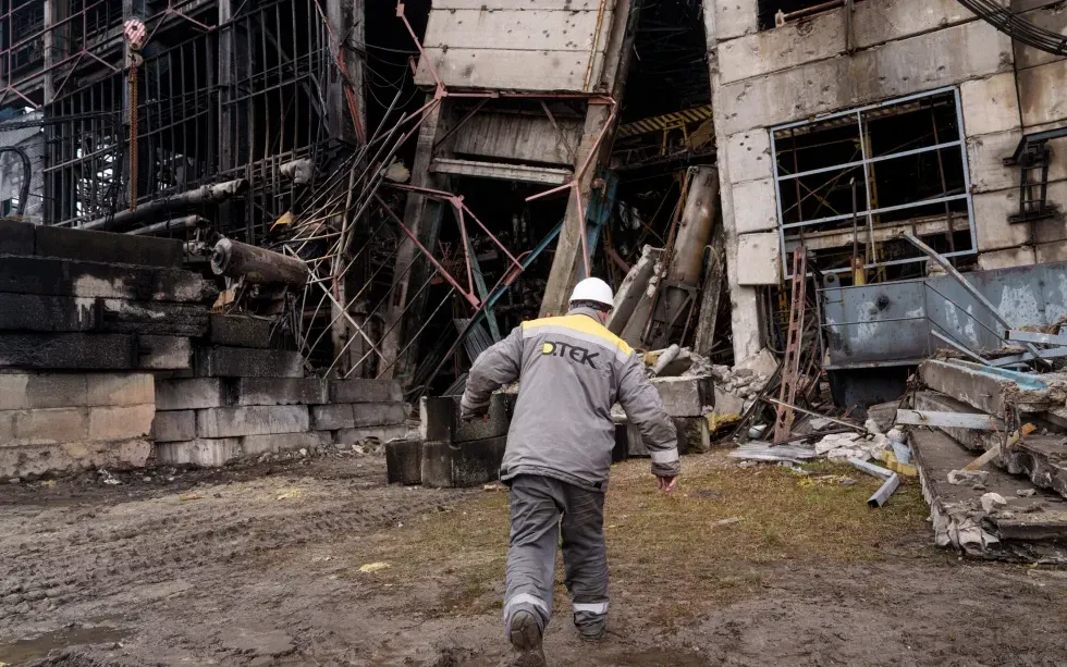 Công nhân đi ngang nhà xưởng bị hư hại sau vụ tấn công tên lửa của Nga tại nhà máy điện DTEK ở Ukraine ngày 10/12/2025 (Ảnh: AP)