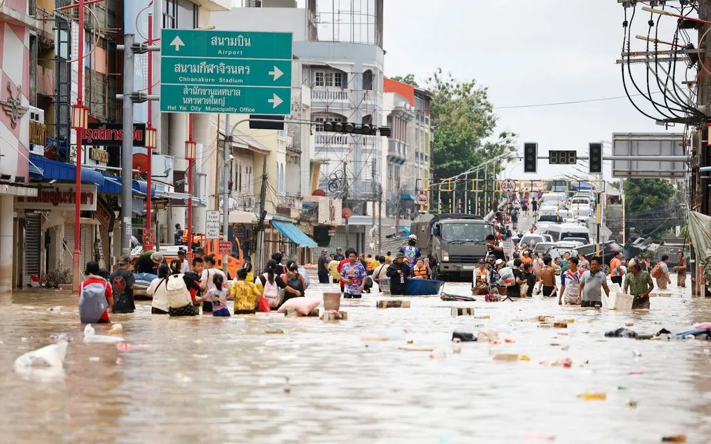 Người dân lội qua vùng nước lũ ở tỉnh Songkhla, miền Nam Thái Lan, ngày 27/11/2025 (Ảnh: AP)