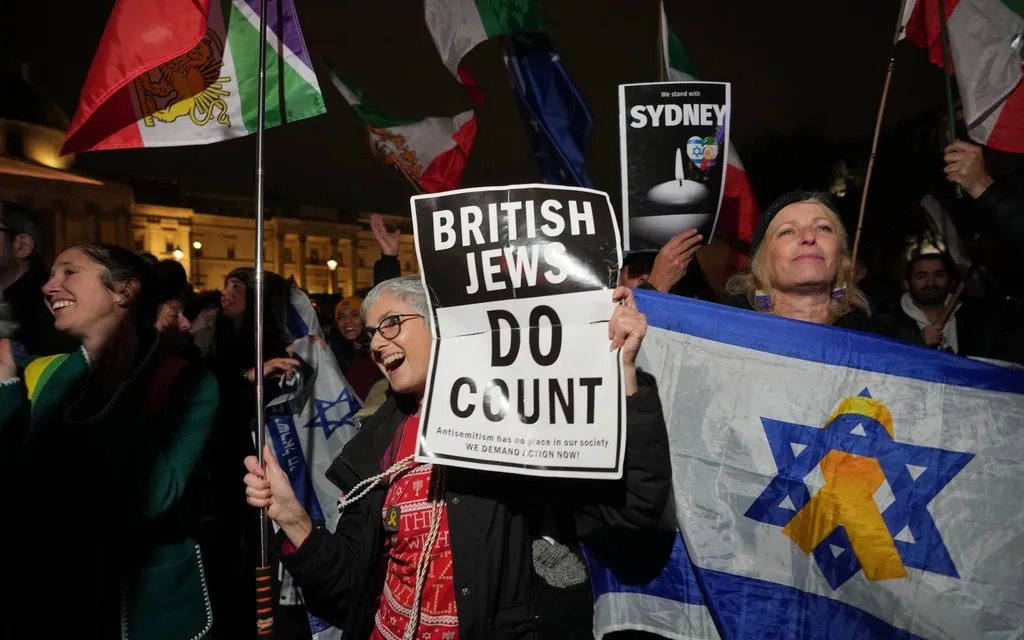 Thành viên cộng đồng Do Thái cầm biểu ngữ tưởng niệm các nạn nhân vụ xả súng tại bãi biển Bondi trong lễ Hanukkah ở Quảng trường Trafalgar, London, ngày 16/12/2025. (Ảnh: AP/Kin Cheung)