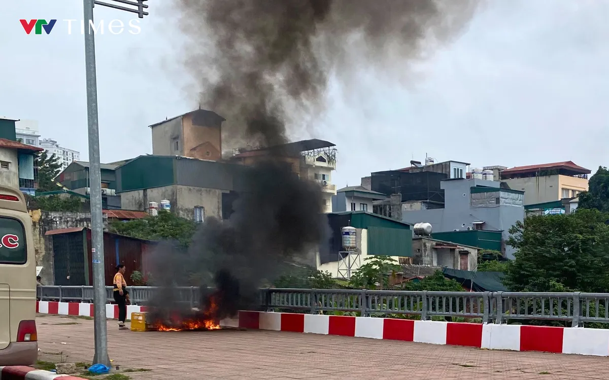 Người phụ nữ thản nhiên đốt rác ngay trên cầu Phố Viên. Ảnh: Hà Linh