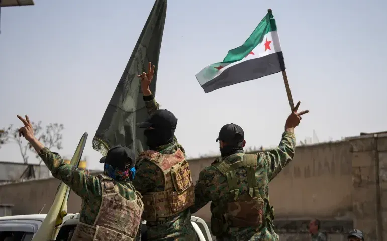 Các thành viên của Lực lượng Dân chủ Syria (SDF) ăn mừng chiến thắng khi rời khỏi thành phố Aleppo, như một phần của thỏa thuận với chính phủ Syria, ngày 9/4/2025 (Ảnh: EFE/EPA)