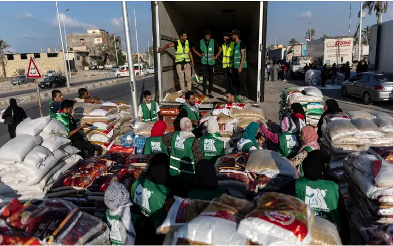 Các tình nguyện viên chất thực phẩm và hàng viện trợ lên xe tải của đoàn xe viện trợ đến Gaza tại Bắc Sinai, Ai Cập (Ảnh: Getty Images)