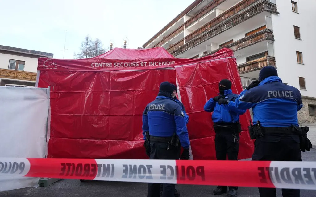 Cảnh sát đứng cạnh lều khẩn cấp bên ngoài quán bar Le Constellation bị phong tỏa tại Crans-Montana, Thụy Sỹ, sau vụ cháy trong đêm đón năm mới, ngày 2/1/2026. (Ảnh: AP)