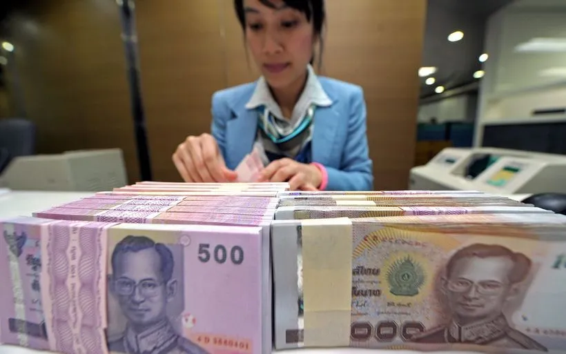 Nhân viên ngân hàng kiểm đếm đồng baht tại Bangkok, Thái Lan. (Ảnh: AFP/TTXVN)