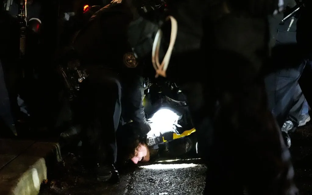 Lực lượng chức năng bắt giữ một người biểu tình bên ngoài cơ sở của ICE tại Portland, Oregon, ngày 8/1/2026 (Ảnh: AP)