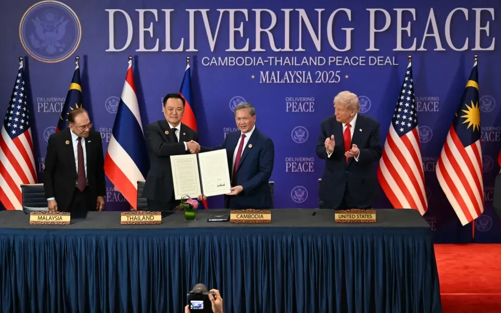 Thủ tướng Malaysia Anwar Ibrahim (bên trái) và Tổng thống Mỹ Donald Trump (bên phải) chứng kiến lễ ký kết thỏa thuận ngừng bắn giữa Thái Lan và Campuchia bên lề Hội nghị thượng đỉnh ASEAN lần thứ 47 tại Kuala Lumpur, ngày 26/10/2025 (Ảnh: AP)