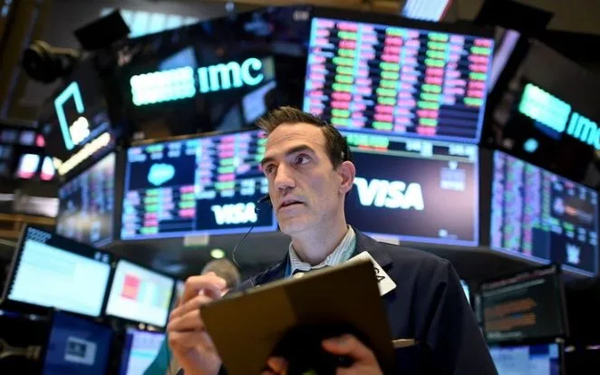 Giao dịch viên tại sàn chứng khoán New York, Mỹ. (Ảnh: AFP/TTXVN)