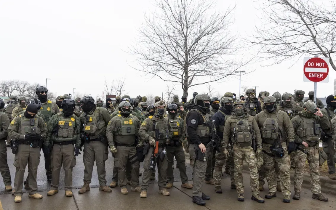Các đặc vụ liên bang Mỹ đứng gác bên ngoài một cơ sở của ICE trong một cuộc biểu tình phản đối ICE ở Minneapolis, ngày 8/1/2026 (Ảnh: Anadolu)
