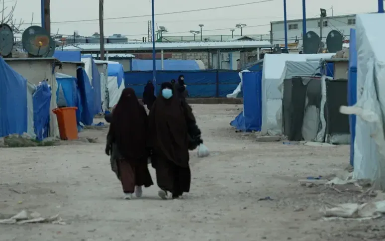 Phụ nữ trùm khăn niqab đi lại bên trong trại giam Al-Roj ở Đông Bắc Syria, do lực lượng SDF canh gác (Ảnh: CNN)