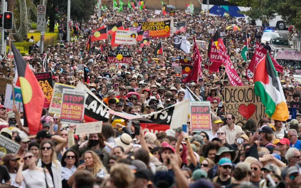 Người biểu tình mang cờ và biểu ngữ trong cuộc tuần hành “Invasion Day” tại Sydney, Australia, ngày 26/1/2026 (Ảnh: AP)