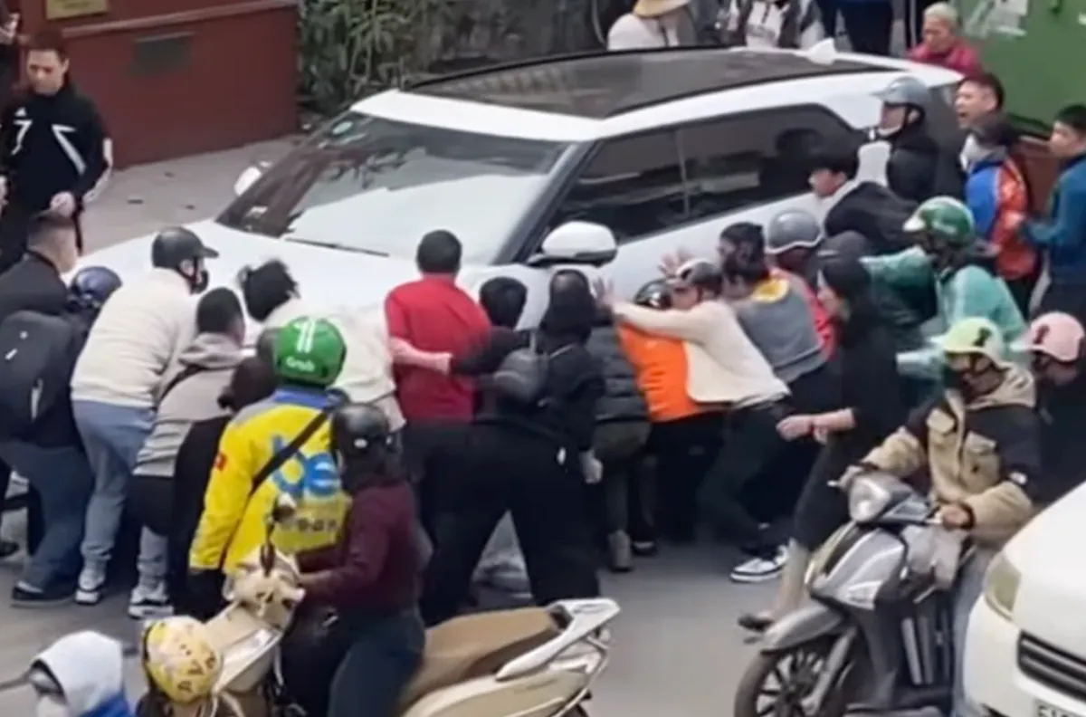 Hà Nội: Người dân hợp sức nâng ô tô đưa một phụ nữ mắc kẹt ra ngoài - Ảnh 2.