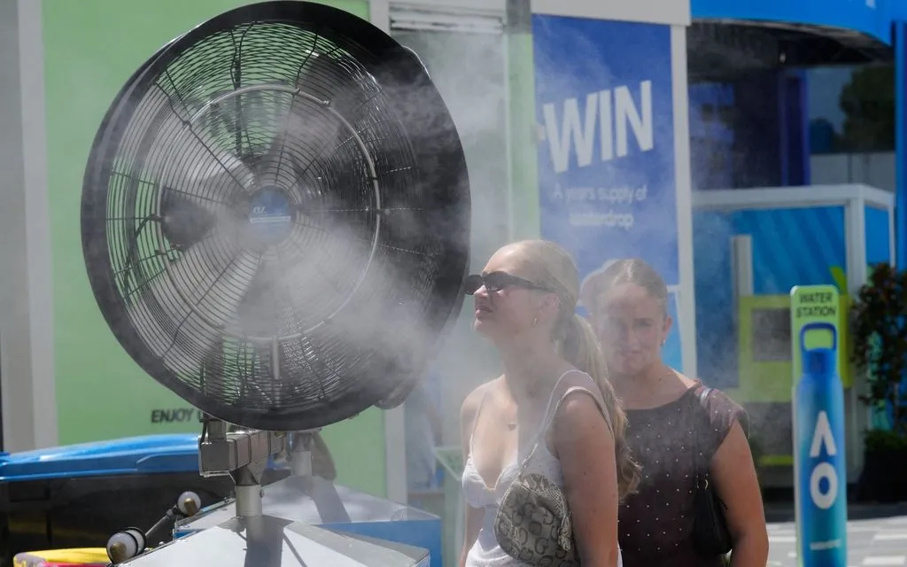 Người hâm mộ làm mát trước hệ thống phun sương ở Melbourne, Australia, ngày 27/1/2026. (Ảnh: AP)