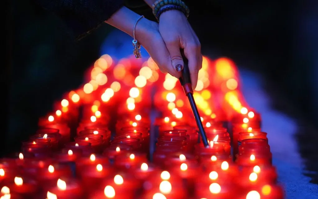 Một phụ nữ thắp nến trong lễ tưởng niệm Ngày Quốc tế Tưởng niệm các Nạn nhân Holocaust tại trại tập trung cũ của Đức Quốc xã ở Terezin, Czech, ngày 27/1/2026. (Ảnh: AP)