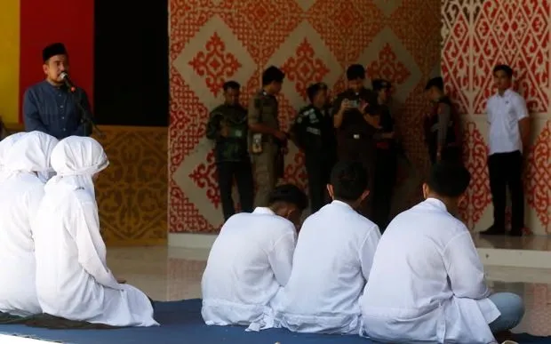 Những người dân Aceh phải chịu hình phạt đánh roi công khai vì vi phạm luật Sharia tại Banda Aceh, Indonesia (Ảnh: EPA)