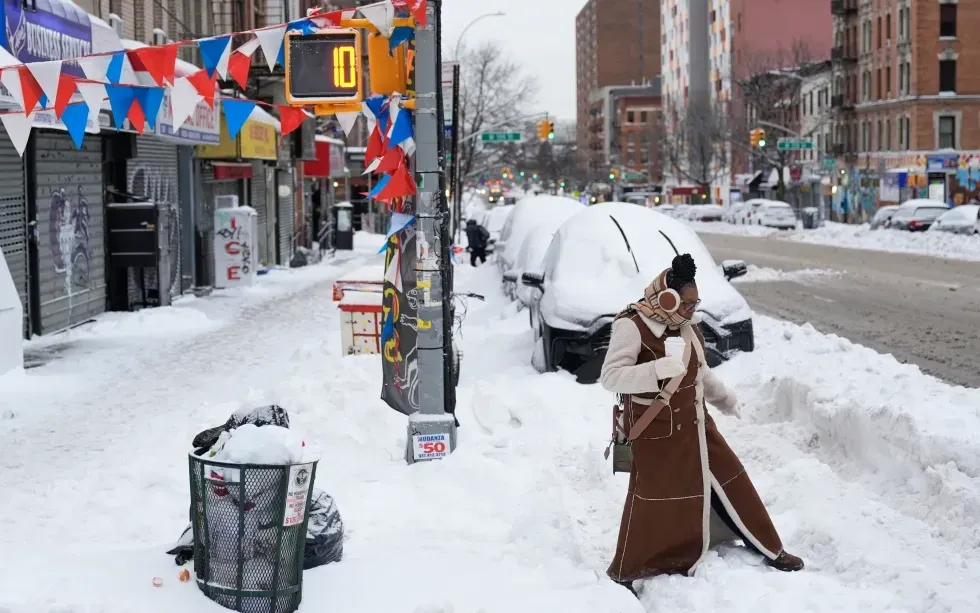 Một phụ nữ di chuyển qua ngã tư phủ tuyết tại New York, ngày 26/1/2026 (Ảnh: AP)