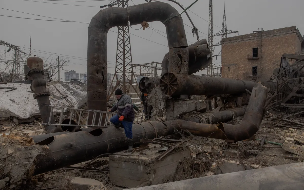 Các công nhân đang sửa chữa những bộ phận của nhà máy nhiệt điện kết hợp Darnytska bị hư hại do các cuộc không kích của Nga tại Kiev hôm 3/2 (Ảnh: AFP)