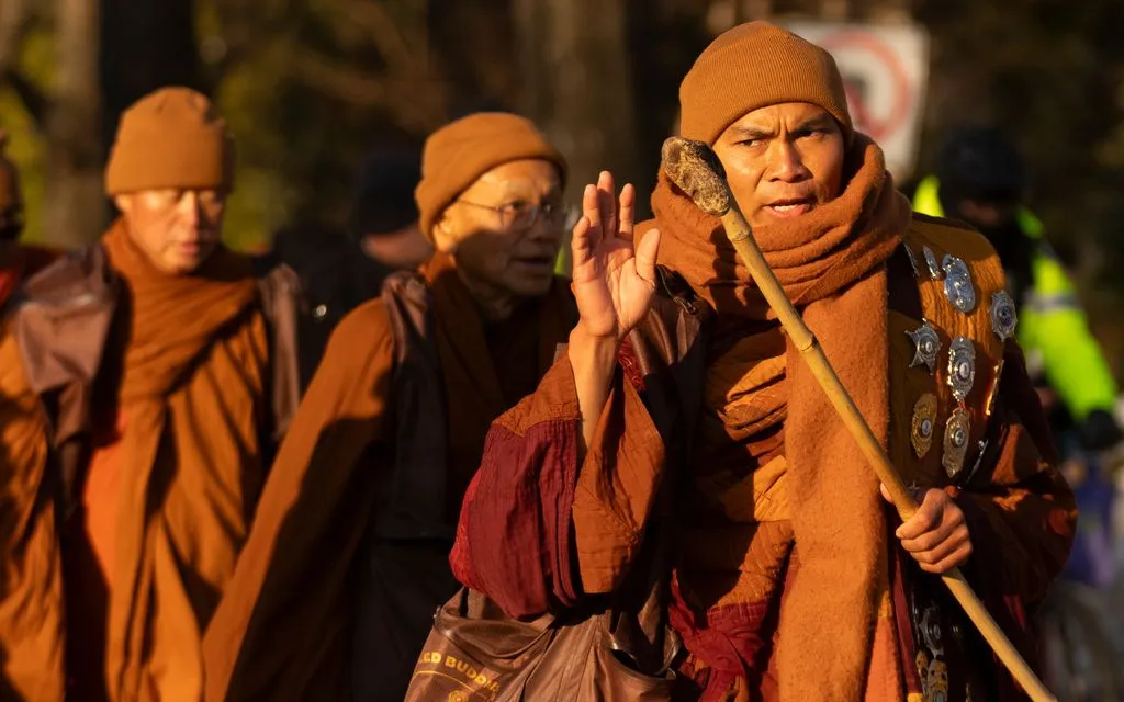 Nhà sư Bhikkhu Pannakara vẫy tay chào khi cùng các nhà sư Phật giáo tham gia hành trình "Walk for Peace" tại Washington, Mỹ ngày 10/2/2026 (Ảnh: AP)