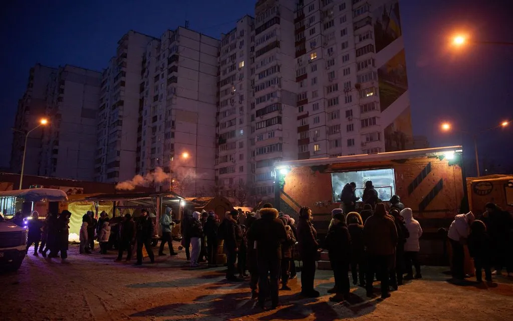 Người dân xếp hàng chờ nhận những bữa ăn nóng miễn phí tại Kiev, trong bối cảnh các cuộc không kích liên tiếp của Nga khiến người dân mất điện, thiếu nguồn sưởi ấm và nước sinh hoạt, ngày 8/2/2026 (Ảnh: AP)